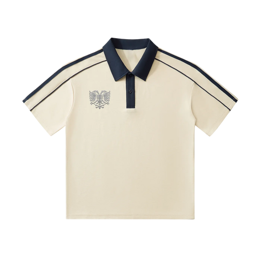 Cream polo shirt with navy collar, sleeve stripes, and eagle emblem embroidery